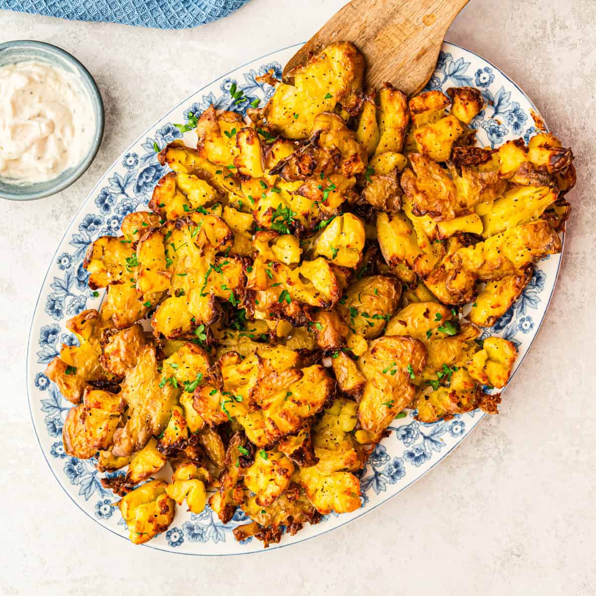 Smashed Potatoes auf weißblauer Servierplatte von oben